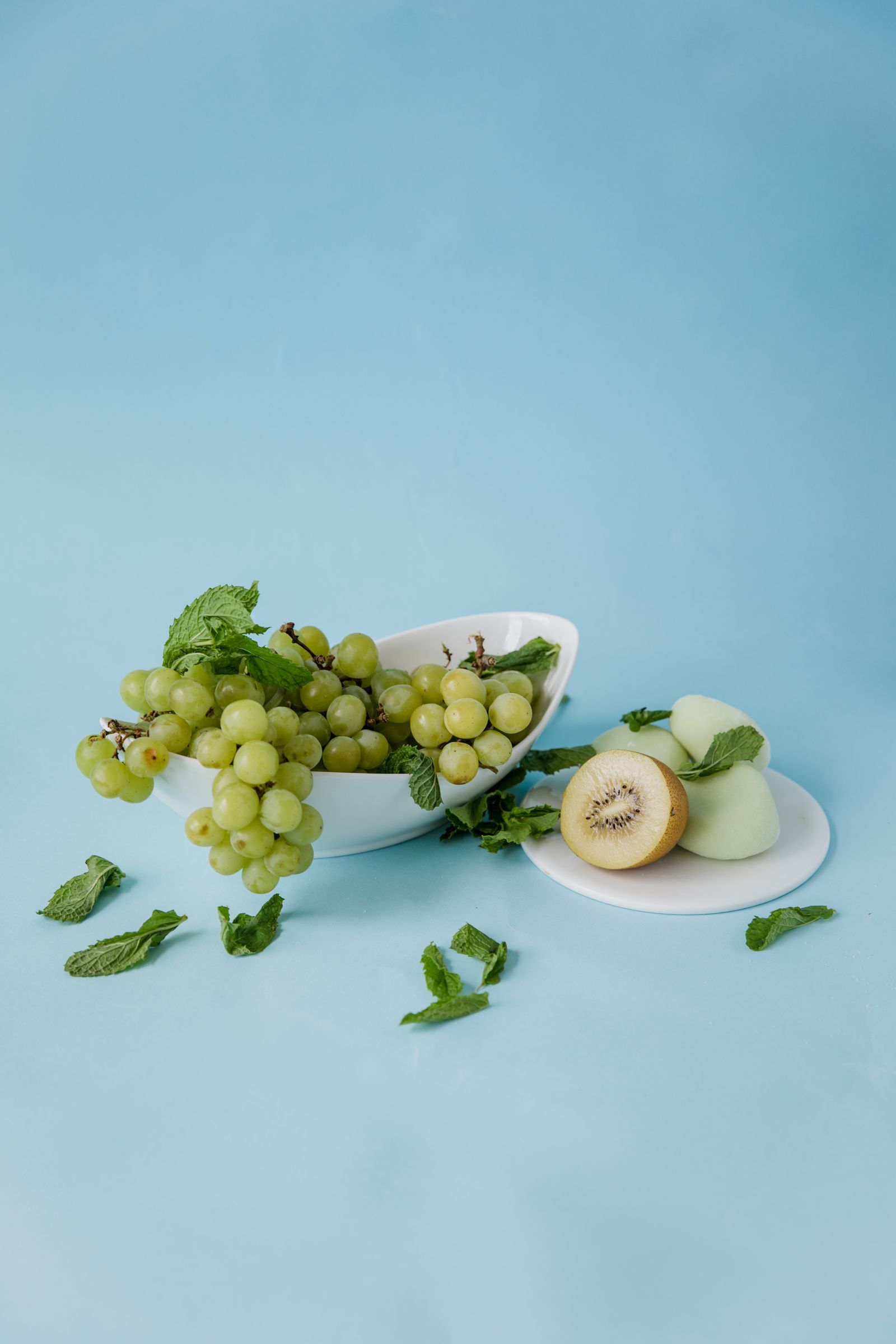 Świeże winogrona i kiwi ułożone na talerzu